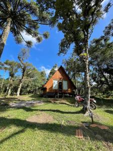 a barn with a motorcycle parked in front of it at Cabana Paradouro da Serra in Cambara do Sul