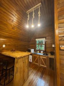 a kitchen with a large island in a wooden cabin at Cabana Paradouro da Serra in Cambara do Sul