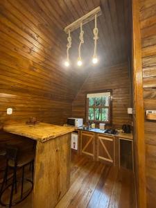 a kitchen with a large island in a wooden cabin at Cabana Paradouro da Serra in Cambará