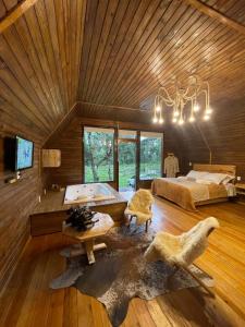 Habitación grande con cama y lámpara de araña. en Cabana Paradouro da Serra en Cambara do Sul