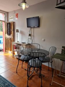 a dining room with a table and chairs and a television at Casina del Puerto in Cudillero