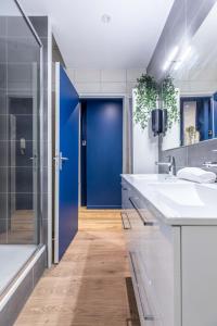 La salle de bains est pourvue de 2 lavabos et d'une porte bleue. dans l'établissement F3 Grand Luxe Champfleuri (B), à Clermont-Ferrand