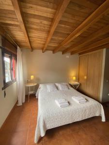 ein Schlafzimmer mit einem Bett mit zwei Waschbecken und einer Holzdecke in der Unterkunft Casina del Puerto in Cudillero