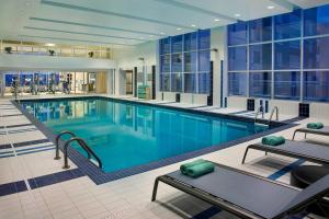 a large swimming pool with blue water in a building at Residence Inn by Marriott Calgary Airport in Calgary