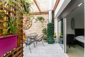 une terrasse avec une table, des chaises et des plantes dans l'établissement L'Oasis Montparnasse, à Paris