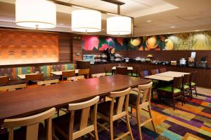 a restaurant with a large wooden table and chairs at Fairfield Inn & Suites Chicago Midway Airport in Bedford Park