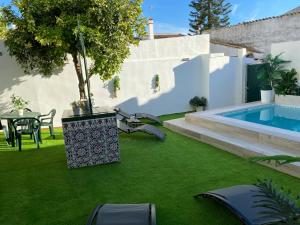 un patio trasero con piscina y césped verde en Esencia Andalucia en Rociana
