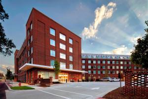 een groot gebouw van rode baksteen voor een parkeerplaats bij Residence Inn by Marriott Durham Duke University Medical Center Area in Durham