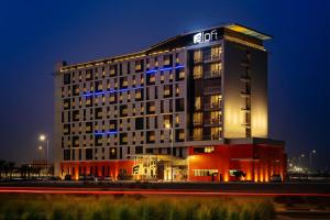 a lit up hotel building at night with at Aloft Dubai South in Dubai