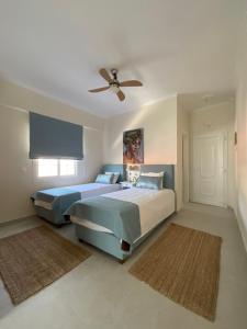 a bedroom with two beds and a ceiling fan at Nereides Suites in Agios Gordios