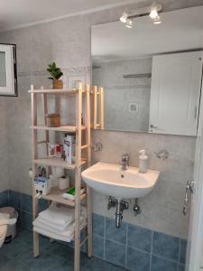 baño con lavabo y estante con espejo en Sofia sea view apartment en Fáros