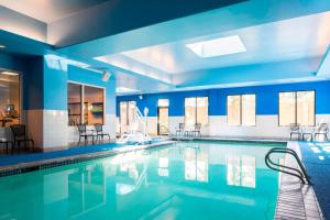 uma grande piscina com paredes e cadeiras azuis em Courtyard by Marriott Seattle Federal Way em Federal Way