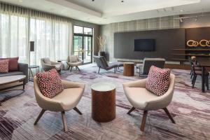 een hotellobby met stoelen en een flatscreen-tv bij Courtyard by Marriott Seattle Federal Way in Federal Way