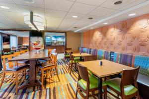 una sala da pranzo con tavoli e sedie in legno di Fairfield by Marriott Inn & Suites Portland Maine Airport a Scarborough