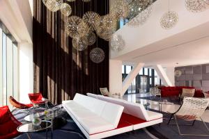 a living room with white furniture and chandeliers at Le Meridien Oran Hotel in Oran