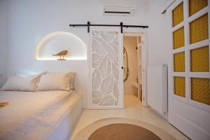 a bedroom with a bed and a door to a bathroom at Λωνη in Aggelika