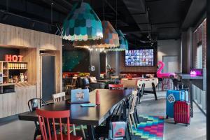 a restaurant with tables and chairs and a pink flamingo at Moxy Amiens in Amiens