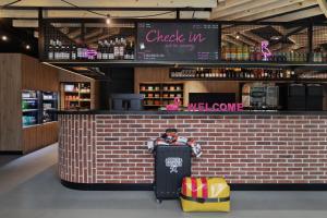 a bar with a luggage bag sitting in front of it at Moxy Amiens in Amiens