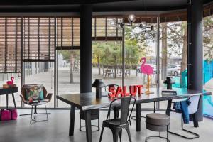 a dining room with a table with a pink flamingo on it at Moxy Amiens in Amiens