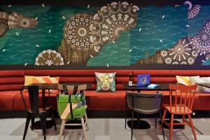 a living room with a red couch and chairs at Moxy Amiens in Amiens