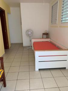 a bedroom with a bed and a fan in a room at LE JARDIN DE GABRIEL in Sainte-Anne +2 photos