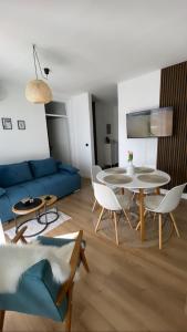 a living room with a blue couch and a table at Comodo apartman Vinkovci in Vinkovci