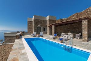 アンドロスにあるAcron Andros - Luxury Villa with Private Poolのスイミングプールとパティオ付きのヴィラ