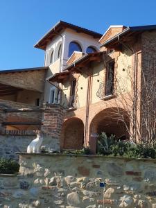 a cat sitting on a wall in front of a house at Relais Colle Messino Briaglia Mondovì in Mondovì
