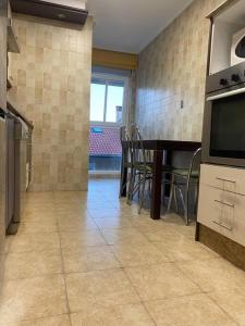 a kitchen with a table and chairs and a television at apartamento cerca de la playa in Salinas +1 photo