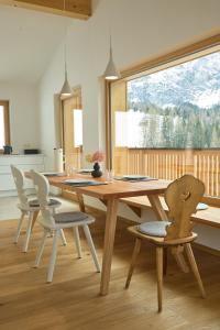 comedor con mesa de madera y sillas en Ciasa Plandros Apartments, en La Valle
