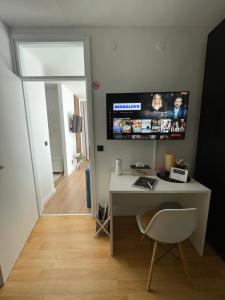 a room with a desk and a tv on the wall at Comodo apartman Vinkovci in Vinkovci