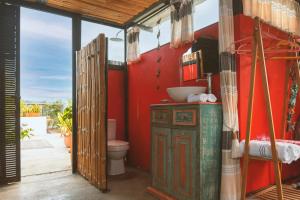 uma casa de banho com um WC e uma parede vermelha em Casa Amberes em Honda