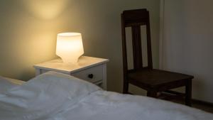 a bedroom with a bed with a lamp and a chair at Pyynikin Rauha in Tampere