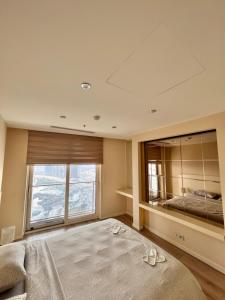 a bedroom with a large bed and a large window at Ottomare Suites sea, view, pool, gym in Istanbul