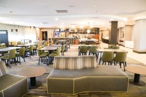 a restaurant with tables and chairs and couches at Courtyard by Marriott Toronto Brampton in Brampton