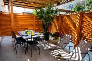 eine Terrasse mit einem Tisch, Stühlen und einem Zaun in der Unterkunft Villa Cinzia in Mondello