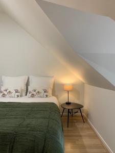 een slaapkamer met een bed en een lamp op een tafel bij Gîte Les Mijoteurs in Rocamadour