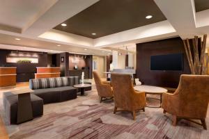 a lobby with a couch and a table and chairs at Courtyard by Marriott Bloomington Normal in Bloomington