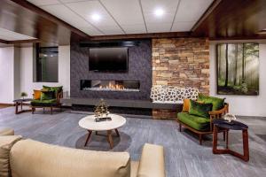 a living room with a fireplace and a tv at Fairfield Inn by Marriott Bangor in Bangor