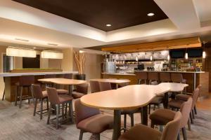 a restaurant with tables and chairs and a bar at Courtyard by Marriott Bloomington Normal in Bloomington