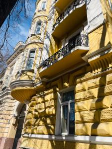 a yellow building with balconies on the side of it at Hostel GARDEN St in Odesa