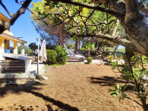 a yard with a umbrella and a car on a street at Villa Gioia Relais in Avola