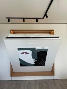 a bed in a room with a painting on the wall at BALI apartment in central Mažeikiai SELF CHECK-IN 24H in Mažeikiai