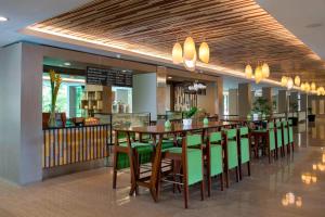 un ristorante con un lungo tavolo e sedie verdi di Marriott’s Bali Nusa Dua Gardens a Nusa Dua