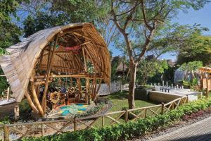a large bamboo building with a roof in a park at Marriott’s Bali Nusa Dua Gardens in Nusa Dua