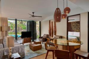 a living room with a couch and a table and a tv at Marriott’s Bali Nusa Dua Gardens in Nusa Dua