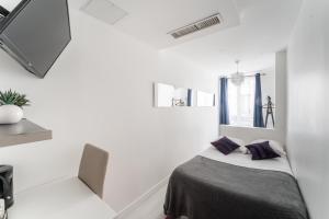 パリにあるL'Oasis Montparnasseの白い部屋(紫色の枕が付くベッド付)