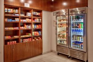 a kitchen with a refrigerator and shelves of food at SpringHill Suites Las Vegas Henderson in Las Vegas