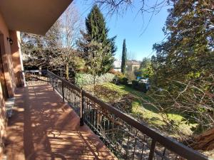 Un balcón de una casa con una valla y árboles en Villa Bice in Maresana, en Ponteranica