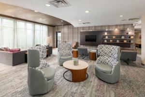 a waiting room with couches and chairs and a television at Courtyard Philadelphia Valley Forge Collegeville in Collegeville